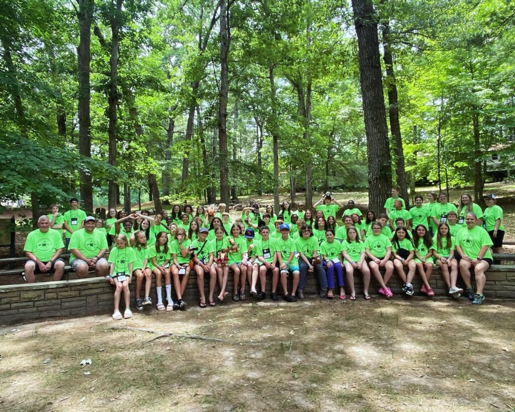 Group of youth wearing green t-shirts at a camp