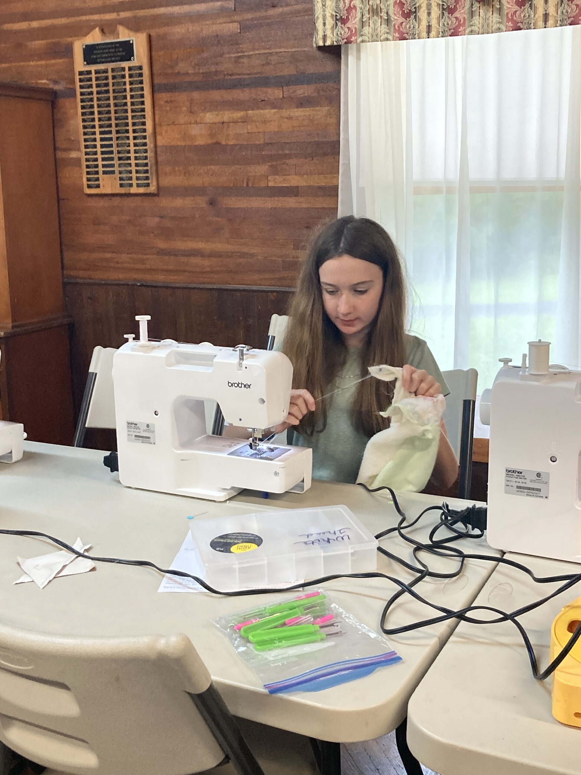 4-H sitting in front of a sewing machine