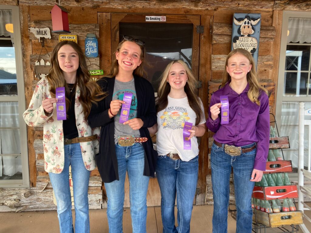 Local 4-Her's holding blue ribbons.