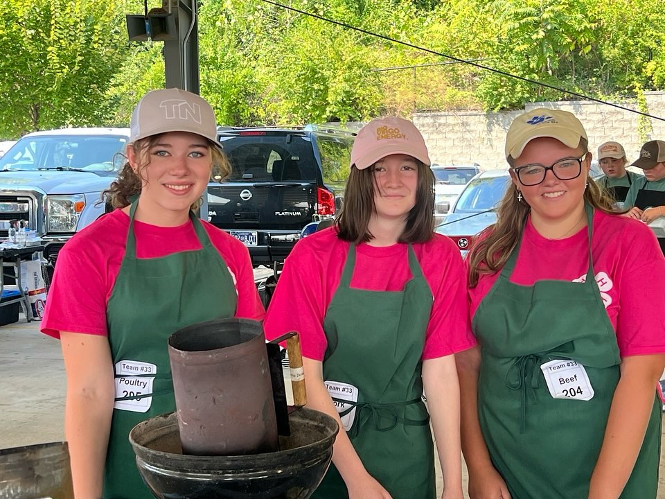 Junior High 4-H Grill Master Team members wearing green aprons and pink shirts.